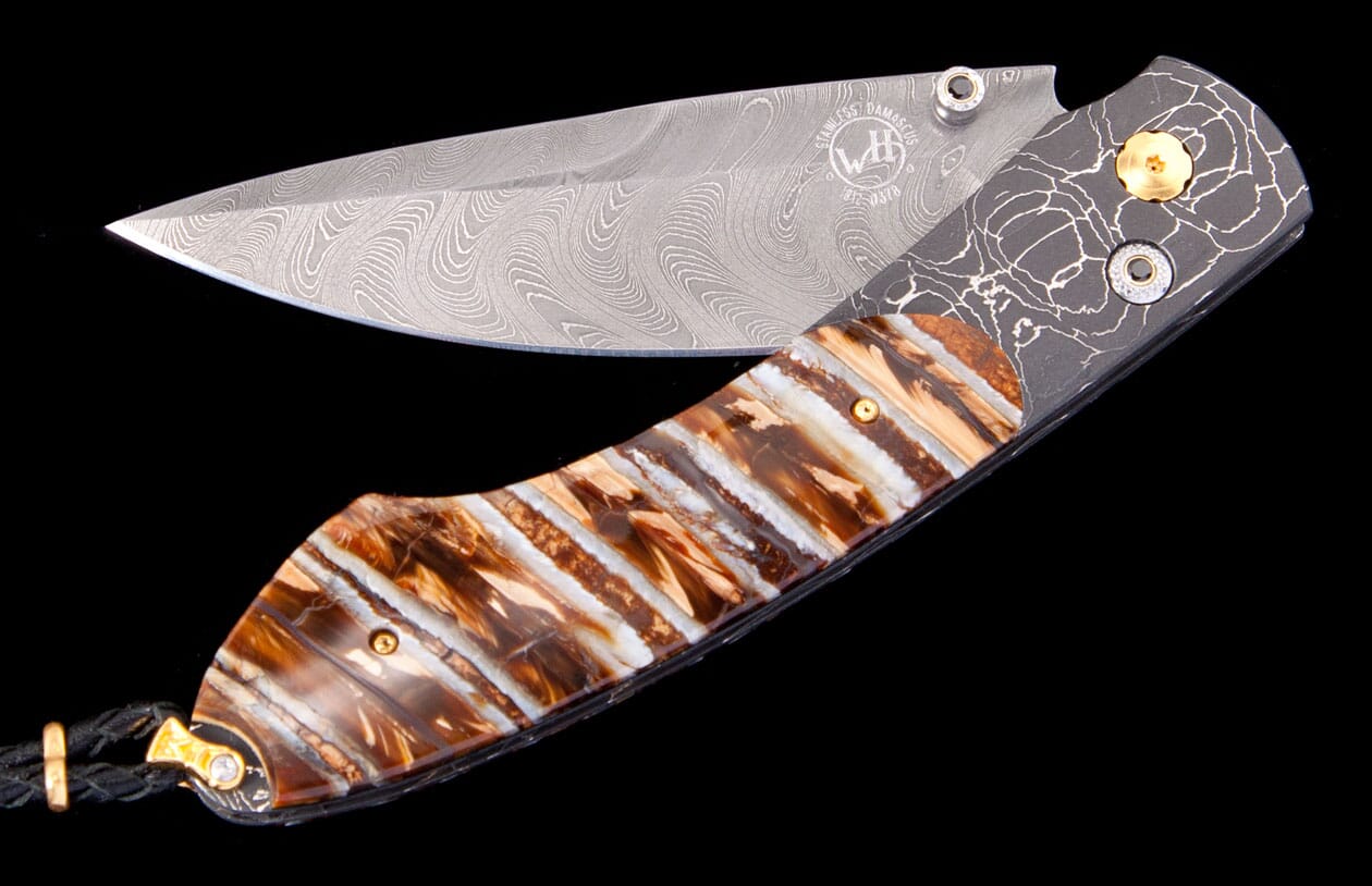 Folding knife with a silver Damascus blade, a brown and white striped handle, and a dark metal bolster with a white crackle design, accented with gold.