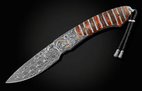 This handcrafted knife from William Henry features hand-engraved depictions of a dragon with 22K and 24K gold. It is inlaid with a stunning piece of 10