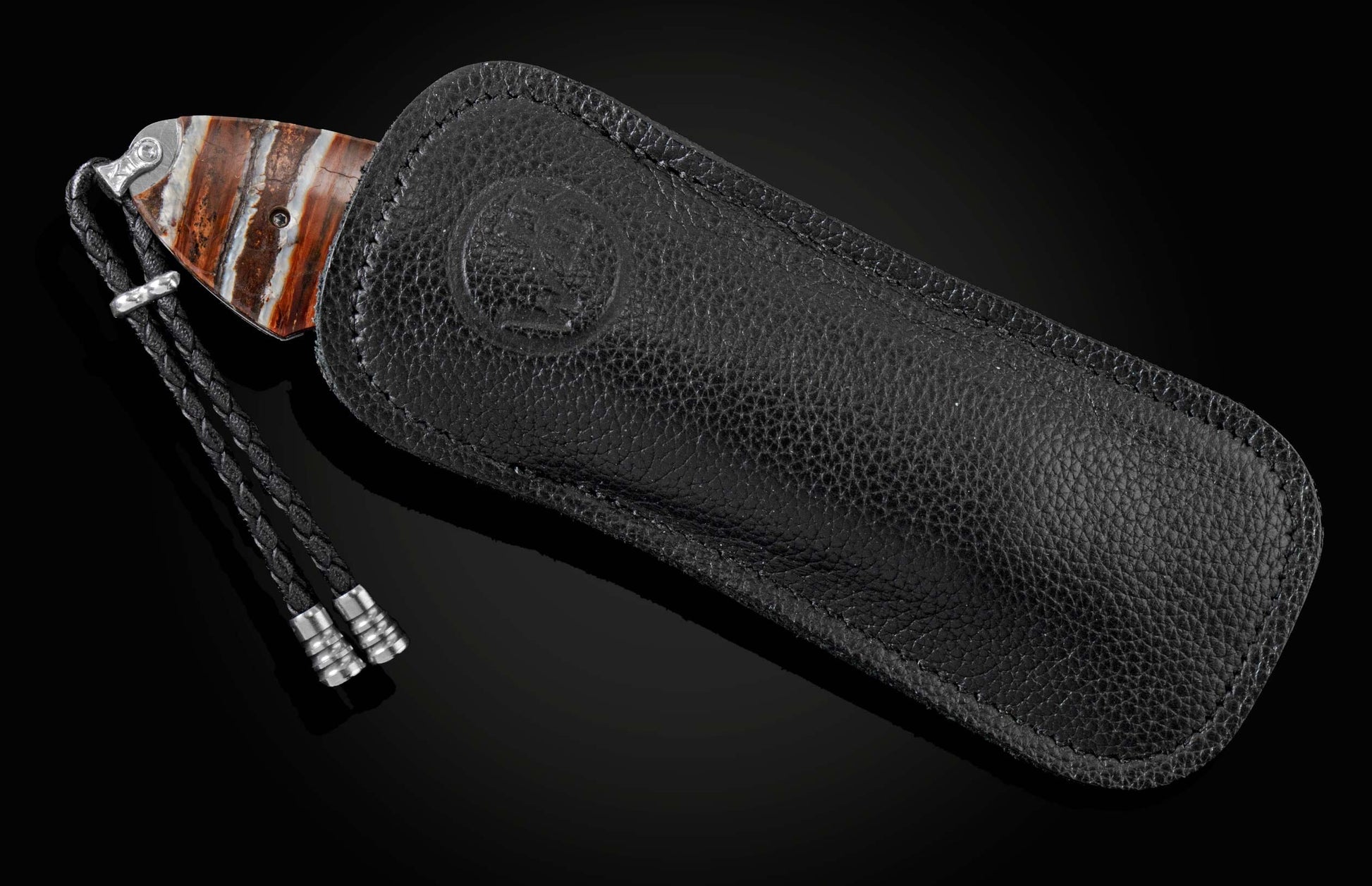 This handcrafted knife from William Henry features hand-engraved depictions of a dragon with 22K and 24K gold. It is inlaid with a stunning piece of 10