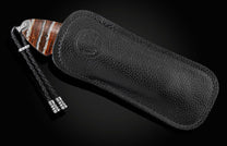 This handcrafted knife from William Henry features hand-engraved depictions of a dragon with 22K and 24K gold. It is inlaid with a stunning piece of 10