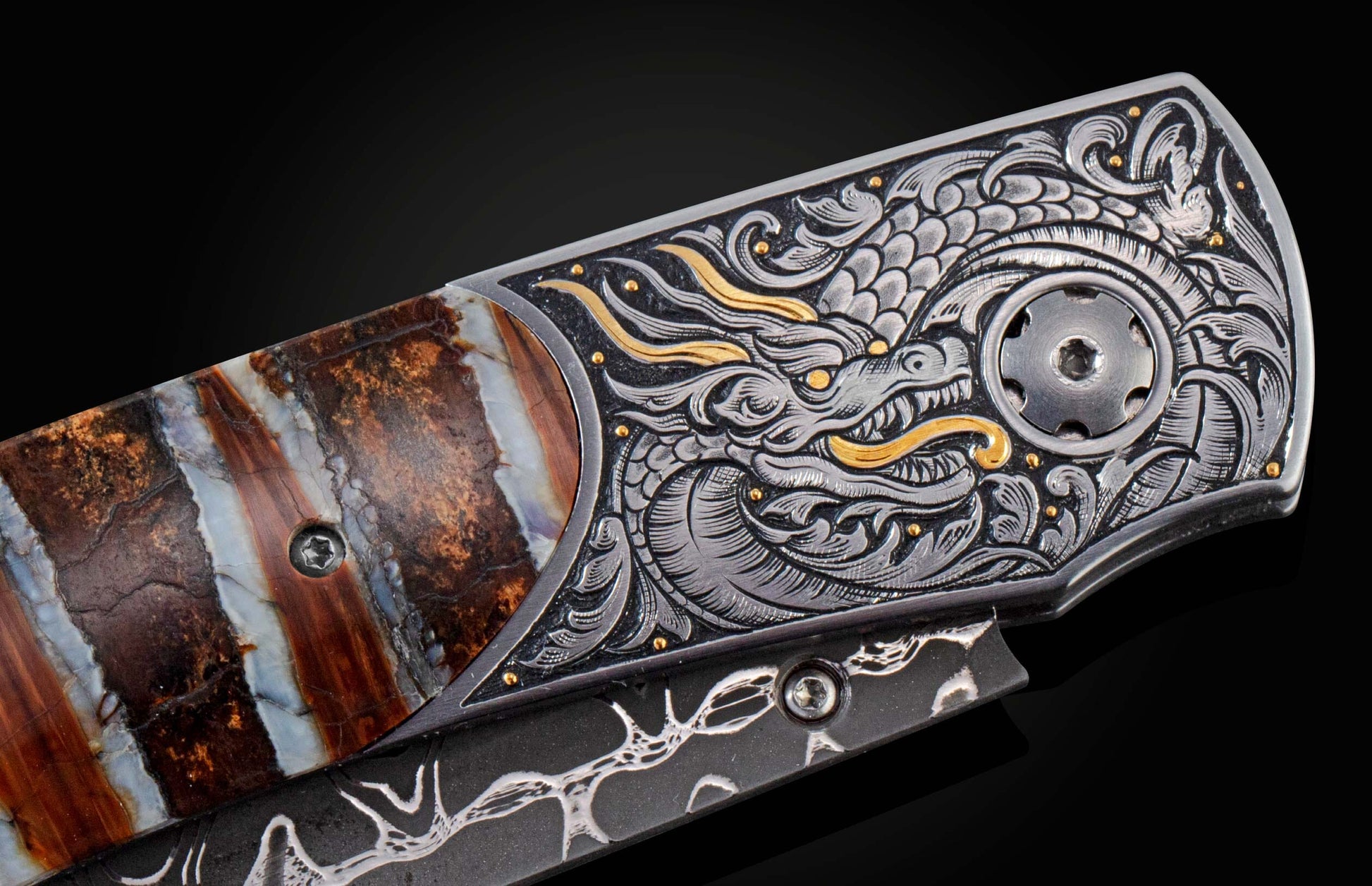 This handcrafted knife from William Henry features hand-engraved depictions of a dragon with 22K and 24K gold. It is inlaid with a stunning piece of 10