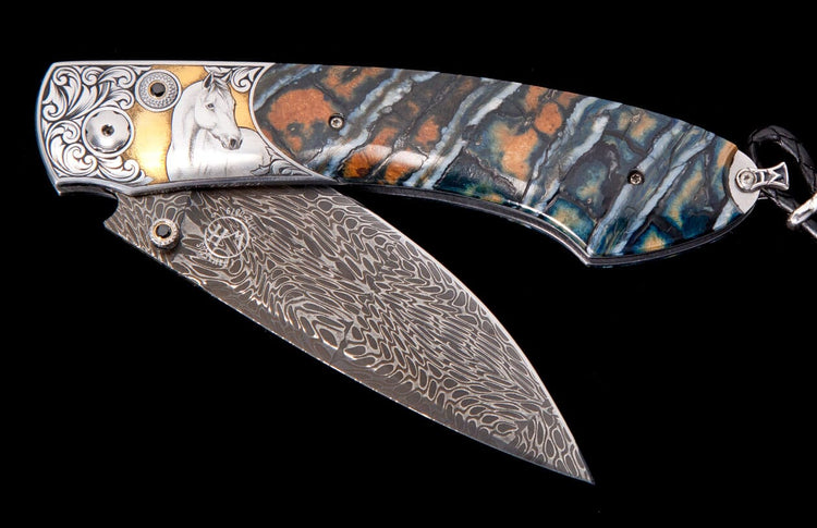 Partially open folding knife with Damascus blade, silver handle featuring gold accents, scrollwork, white horse design, and multi-colored patterned scales.