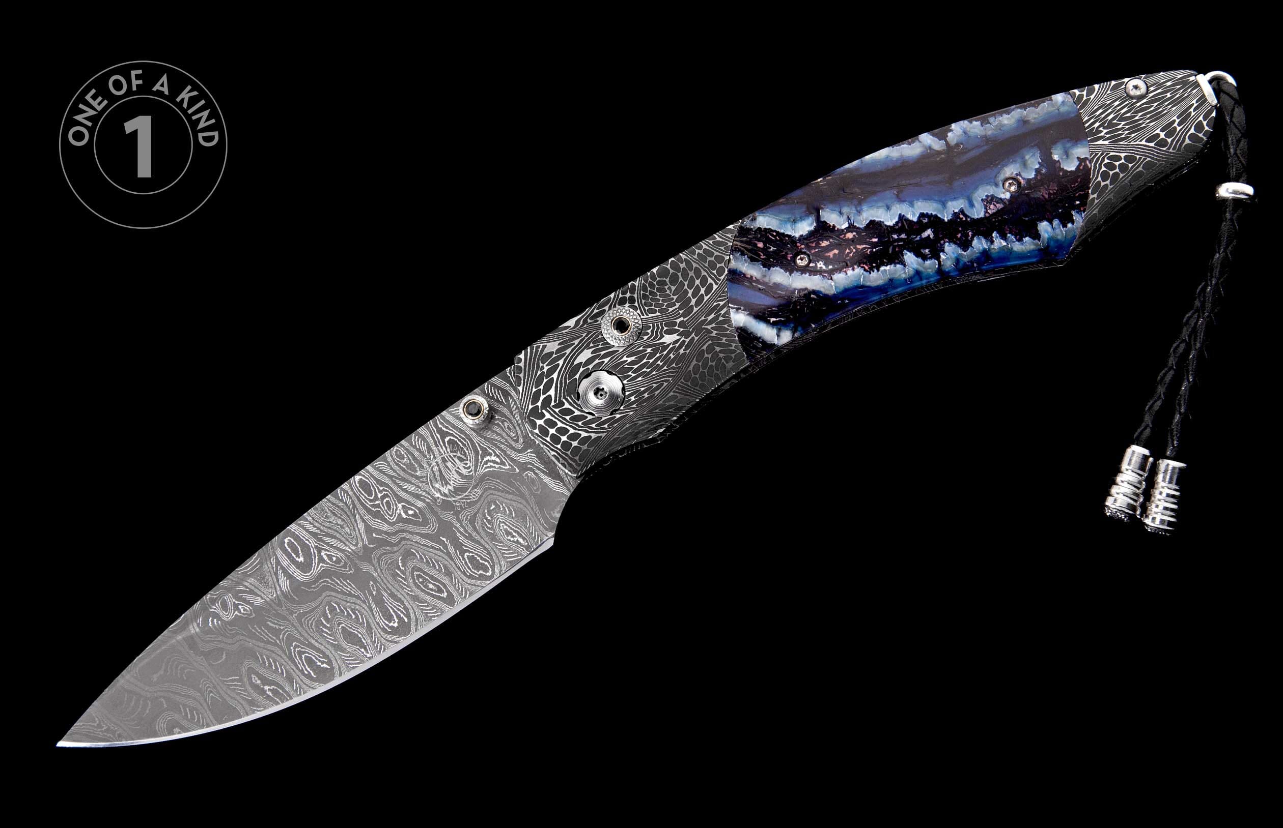 Knife with a Damascus patterned blade and a blue, purple, and white agate-like handle, with silver lanyard beads, displayed diagonally with a 'One of a Kind' label.