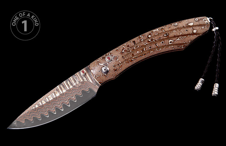 Damascus steel knife with brown and white swirling pattern, red gem inlays, silver accents, and a black leather lanyard.
