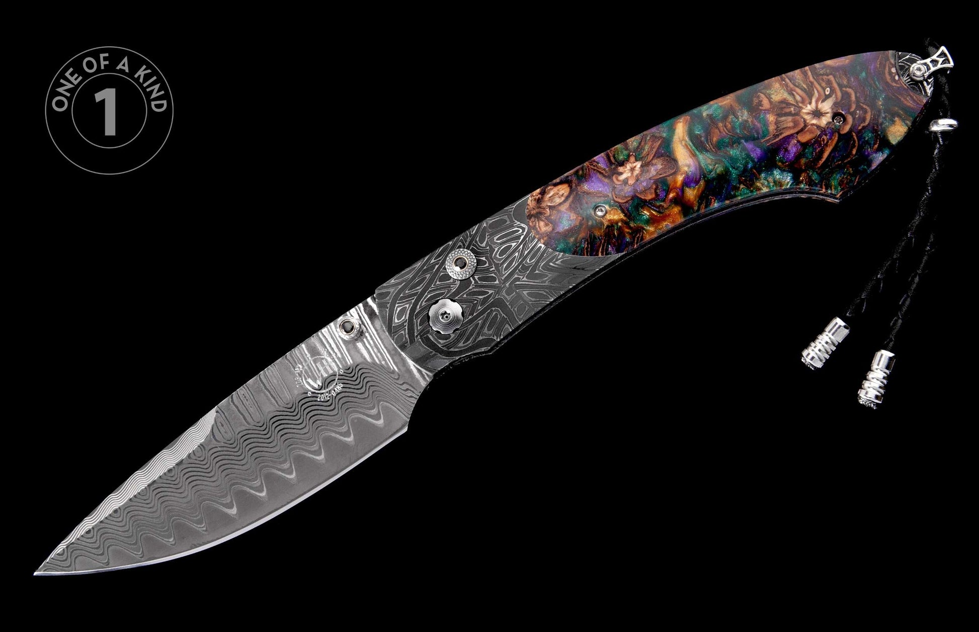 A folding knife with a wavy Damascus steel blade, a multi-colored resin handle with abstract floral patterns, and a black lanyard.