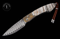 Ornate folding knife with a wavy Damascus steel blade, gold-etched handle details, and white cracked handle scales, finished with a brown leather lanyard.