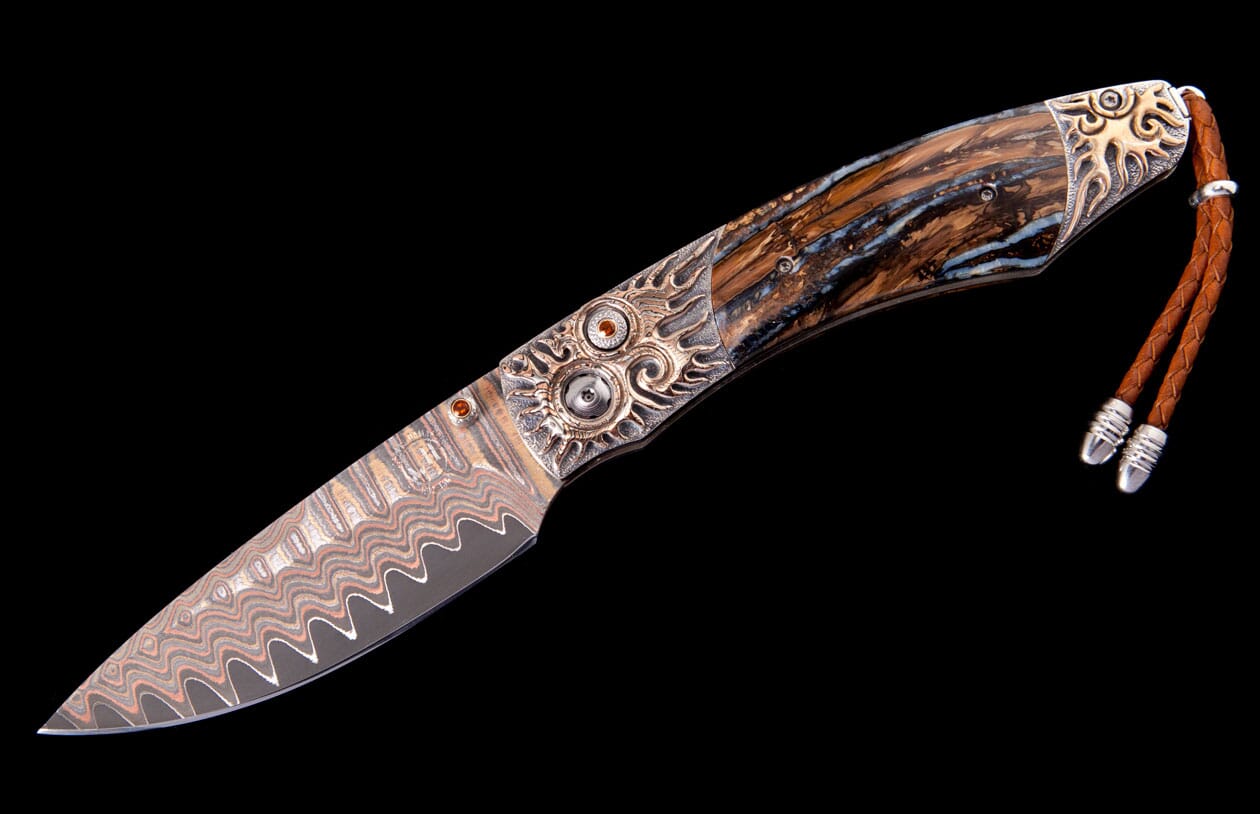 Ornate folding knife with Damascus blade, swirl-patterned brown and blue handle, detailed silver bolsters, and a braided leather lanyard.