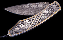 Ornate custom knife with a damascus steel blade, silver scrollwork engraving, gold accents, and five diamond flower clusters.
