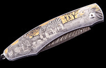 Engraved folding knife with a detailed safari scene of a cheetah, zebras, and an eagle on its silver and gold handle.