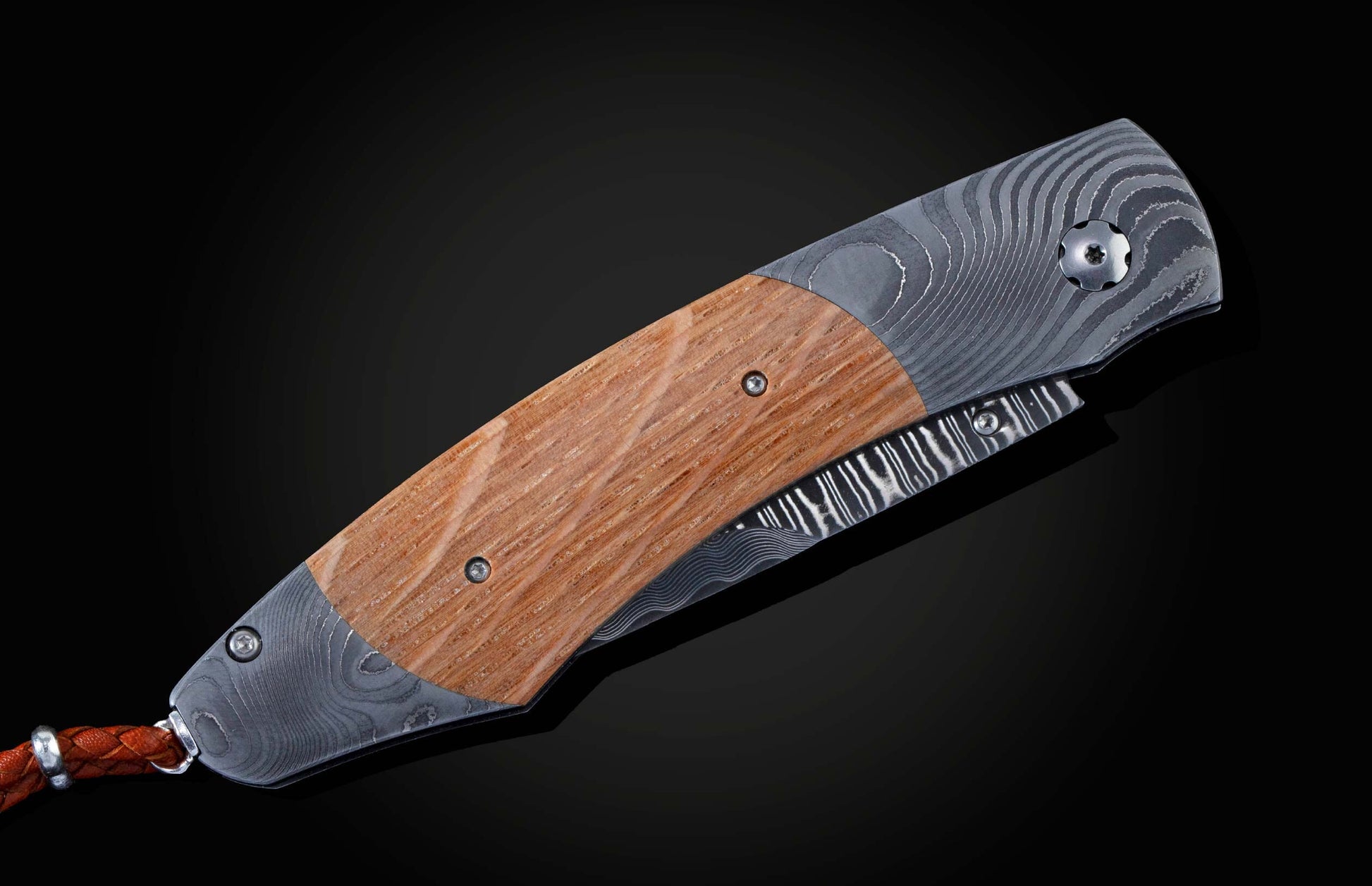 Handcrafted pocket knife from William Henry features a beautiful frame in Damascus steel inlaid with barrel wood from Pappy Van Winkle Bourbon