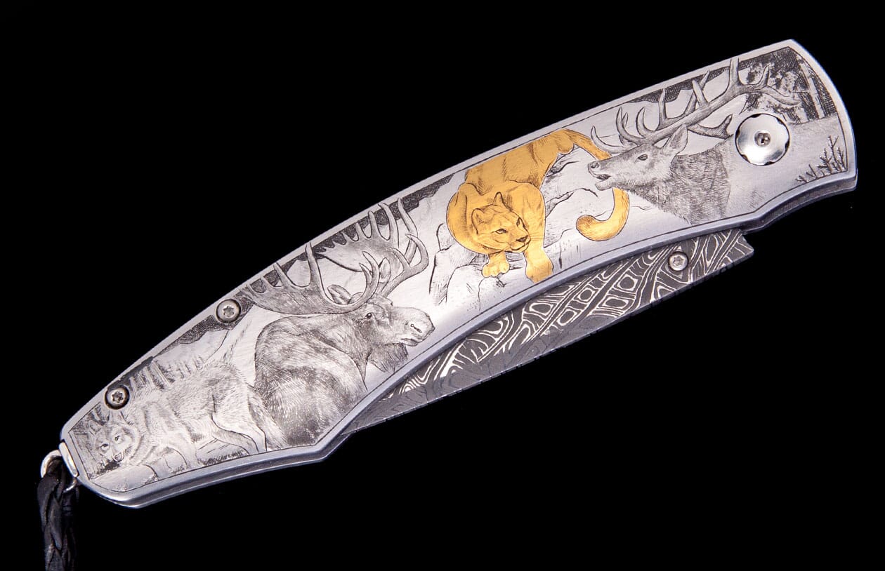 Engraved folding knife with silver-toned handle featuring wildlife art of a moose, wolf, gold cougar, and deer, with a Damascus blade.