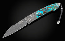 Handcrafted William Henry custom automatic knife features a hand forged Damascus steel frame by Chad Nichols, inlaid with 'Black Matrix' turquoise, spinel gemstones, and a hand-forged Damascus steel blade, also by Chad Nichols.