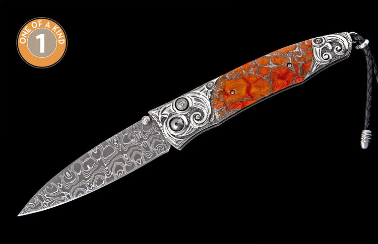 Ornate folding knife with a swirling damascus blade, orange marbled handle, intricate silver details, a leather lanyard, and a 'ONE OF A KIND 1' emblem.