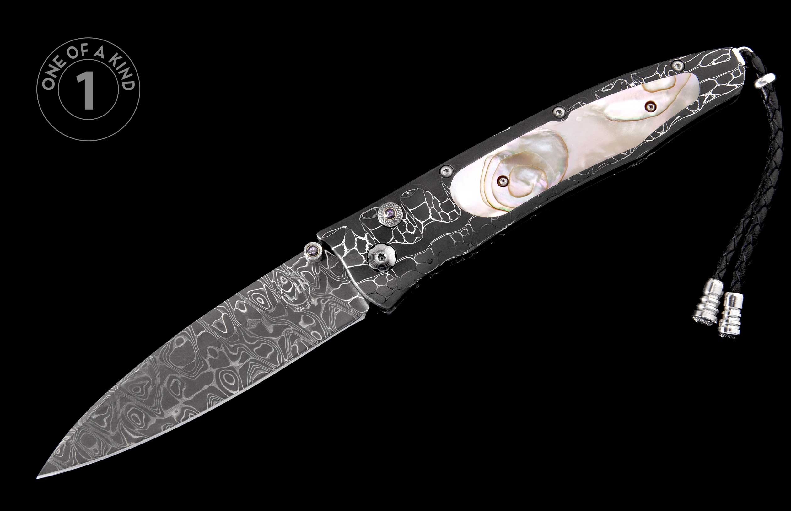 Damascus steel folding knife with a black handle, white organic patterns, iridescent mother-of-pearl inlays, and a black braided leather lanyard.