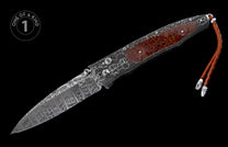 Open folding knife with patterned Damascus steel blade, patterned dark handle with textured red-brown inlay, and braided leather lanyard.