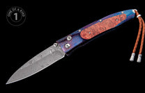 Folding knife with a Damascus blade, burl wood handle, blue and purple patterned metal, a brown braided leather lanyard, and a 'one of a kind' badge.