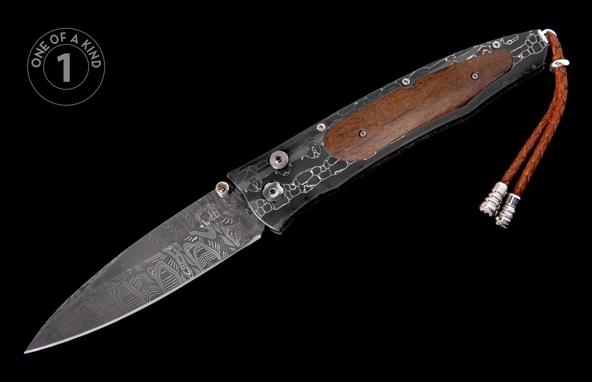 Folding knife with a patterned Damascus steel blade, dark etched frame, brown wood handle, and braided leather lanyard.