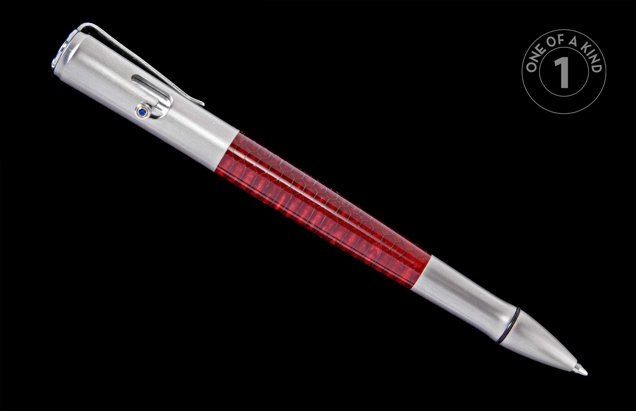 Silver pen with a red, honeycomb-textured barrel and a blue accent jewel, angled on a black background.