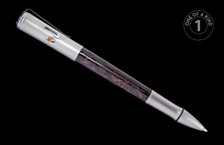 Sleek metal pen with a transparent barrel revealing dark material with orange flecks, featuring a brushed silver clip with an amber accent.
