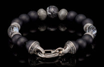 Black matte bead bracelet by William Henry, featuring ornate sterling silver spacers, a patterned bead, and an engraved clasp.