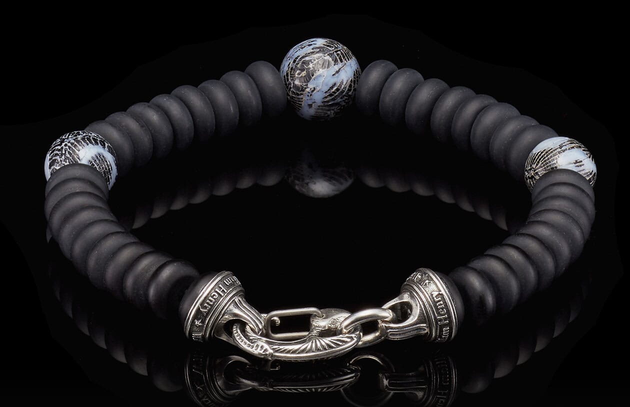 Black matte disc bead bracelet with three abstract blue/white patterned beads and an ornate silver clasp engraved "Tim Henry".