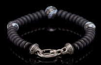 Black matte disc bead bracelet with three abstract blue/white patterned beads and an ornate silver clasp engraved "Tim Henry".