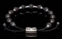 Black lava stone beaded bracelet with silver-tone spacers, a textured silver clasp, and adjustable black cord.
