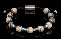 Adjustable bracelet with spherical, naturally banded beads in cream, brown, and black, dark metal spacers, and a hammered clasp.