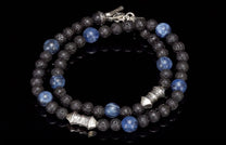 A coiled beaded necklace/bracelet with blue sodalite and black lava beads, featuring ornate silver spacers and clasp.