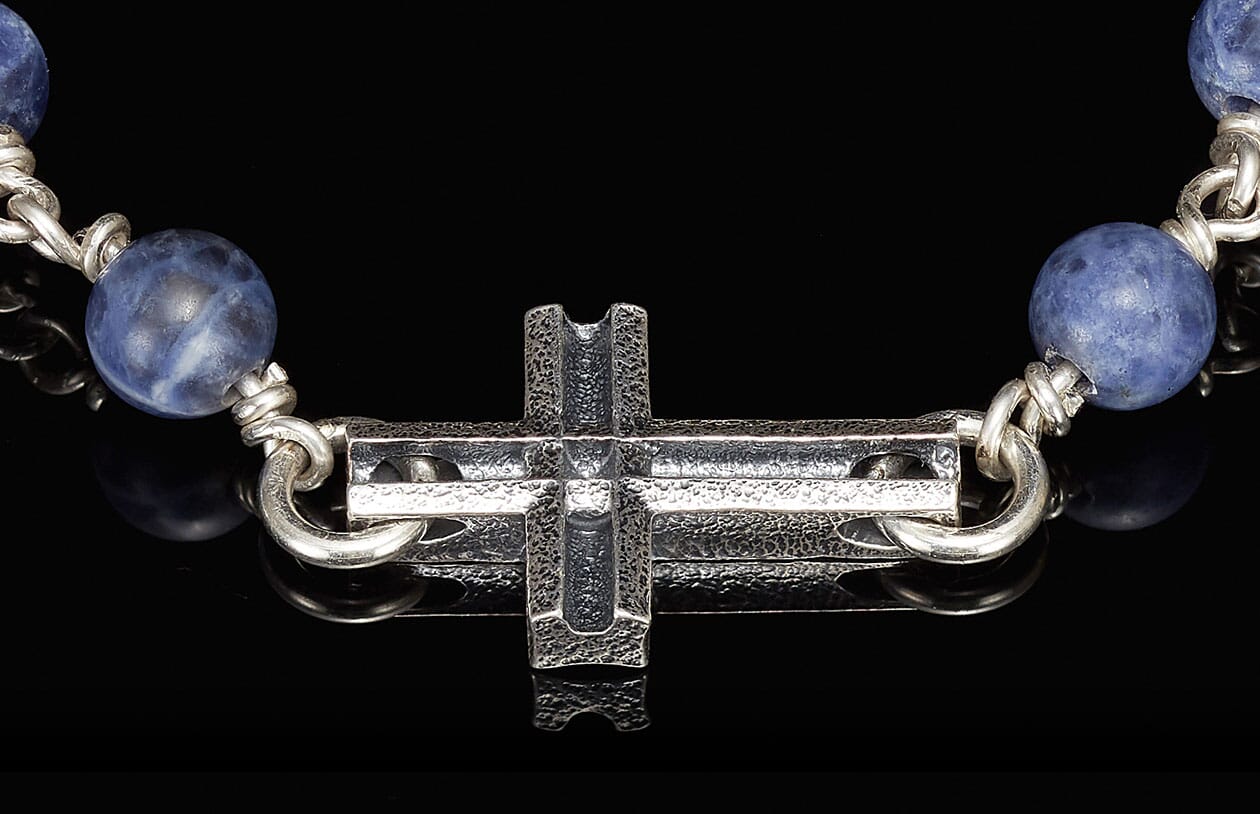 Blue sodalite beaded religious jewelry featuring a hammered silver cross centerpiece.