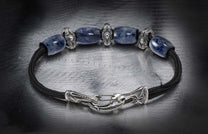 Blue sodalite bracelet with black braided cord and ornate silver-toned beads and a decorative hook clasp.