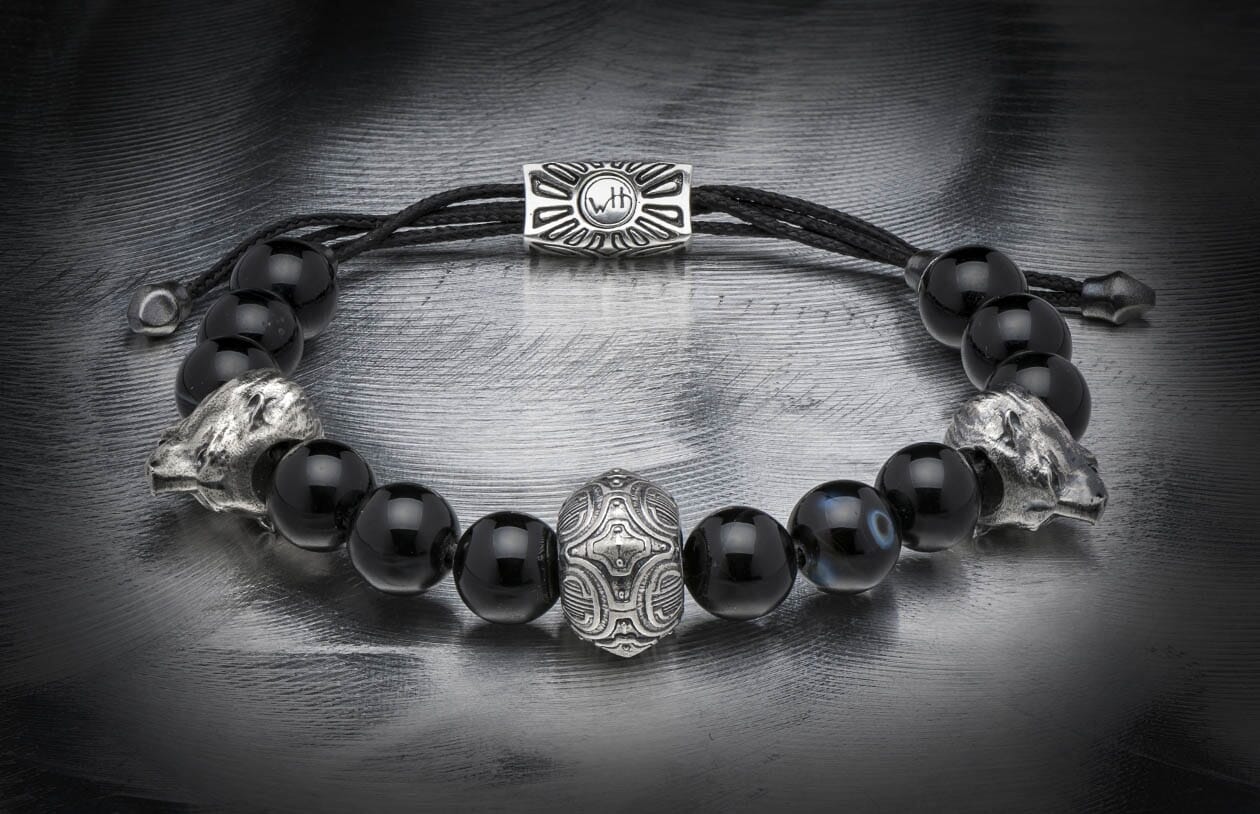 Black beaded bracelet featuring silver lion head beads, a central ornate silver bead, and a rectangular clasp with 'WTH' engraving.