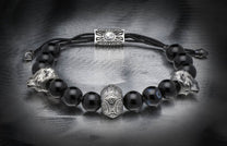 Black beaded bracelet featuring silver lion head beads, a central ornate silver bead, and a rectangular clasp with 'WTH' engraving.