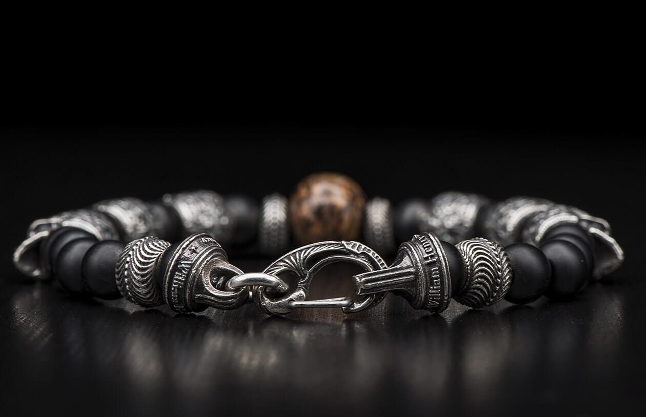 Black matte beaded bracelet with patterned silver-toned metal beads engraved 'William Henry', an ornate clasp, and a central bronze bead.