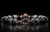 Black matte beaded bracelet with patterned silver-toned metal beads engraved 'William Henry', an ornate clasp, and a central bronze bead.