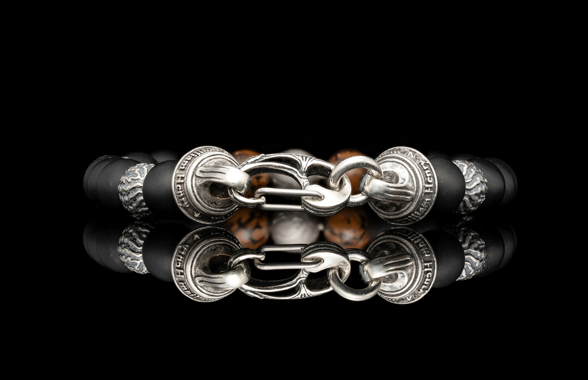 Beaded bracelet with meteorite, dinosaur bone, silver and onyx beads on a dark background