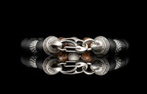 Beaded bracelet with meteorite, dinosaur bone, silver and onyx beads on a dark background