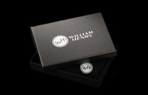 ZBF LIZ BLK MT|Textured black gift box by William Henry for a leather Zipper Bi-Fold, partially open revealing a 'WH' logo inside.