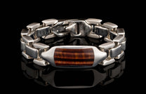 Silver bracelet with a rectangular red tiger eye stone centerpiece, featuring polished links and a '925' stamped clasp.