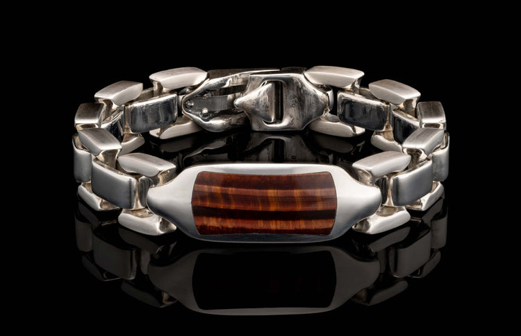 Silver bracelet with a rectangular red tiger eye stone centerpiece, featuring polished links and a '925' stamped clasp.