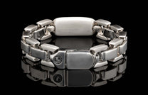 Silver-toned metal bracelet with chunky rectangular links, featuring a '925' hallmark and circular logo on the clasp.