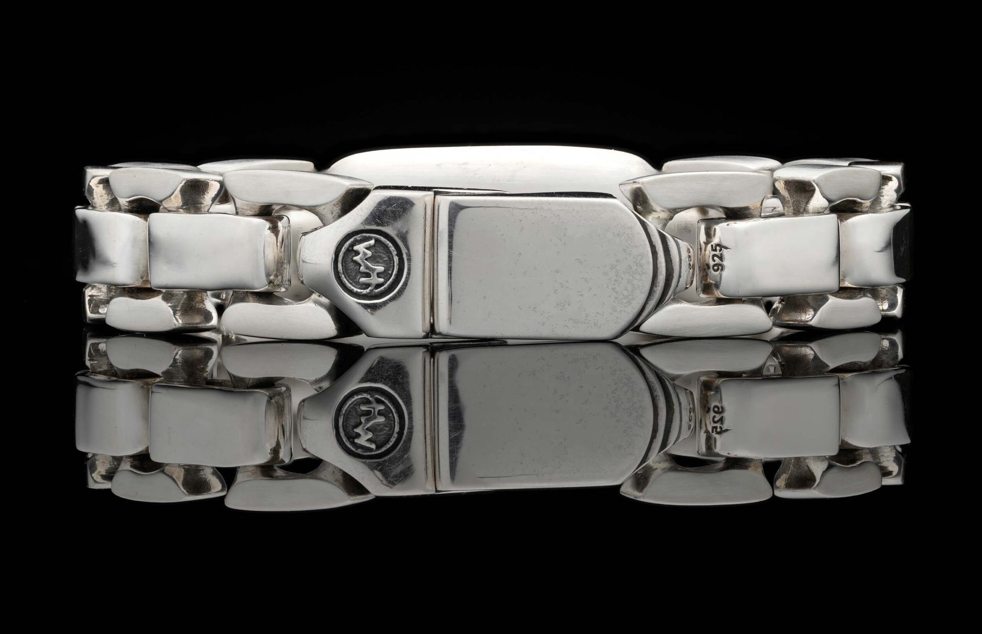 Silver identity bracelet with chunky rectangular links and a prominent clasp engraved with 'WM' and '925'.