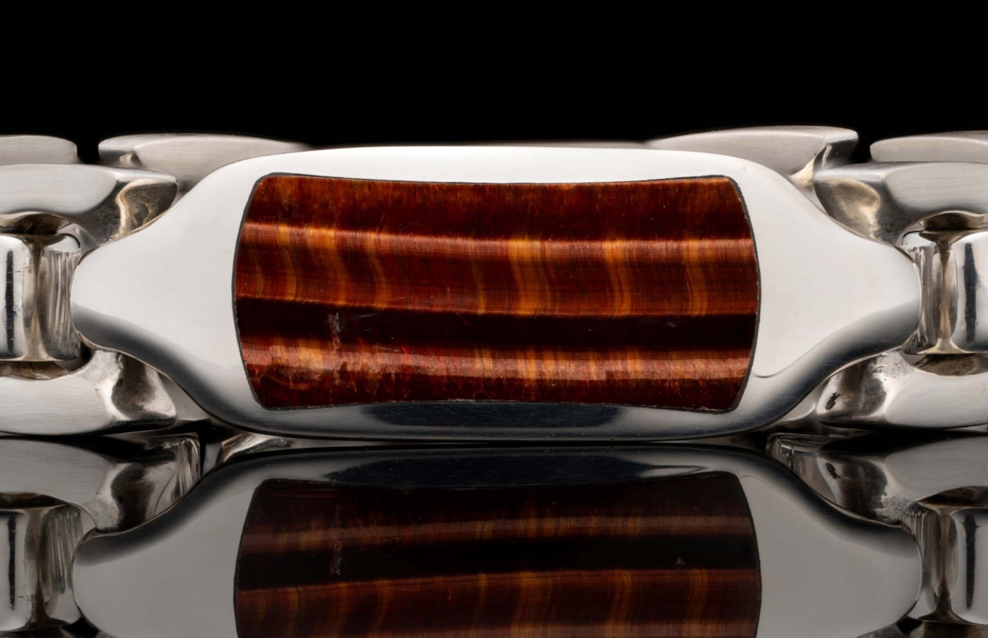 Polished silver-toned bracelet with a rectangular red tiger eye inlay featuring shimmering horizontal bands.