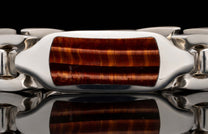 Polished silver-toned bracelet with a rectangular red tiger eye inlay featuring shimmering horizontal bands.