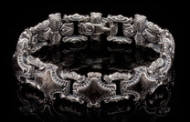 Silver-toned metal "Pawn" bracelet featuring ornate, etched links with scrollwork and a visible clasp with 'KA' emblem.
