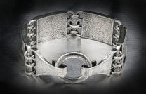Textured silver-toned metal bracelet with wide hammered links, connected by smooth rings, and a central textured hoop.