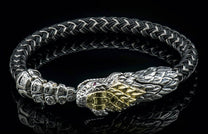 Black and silver braided bracelet featuring a silver snake head with gold accents and a red eye.