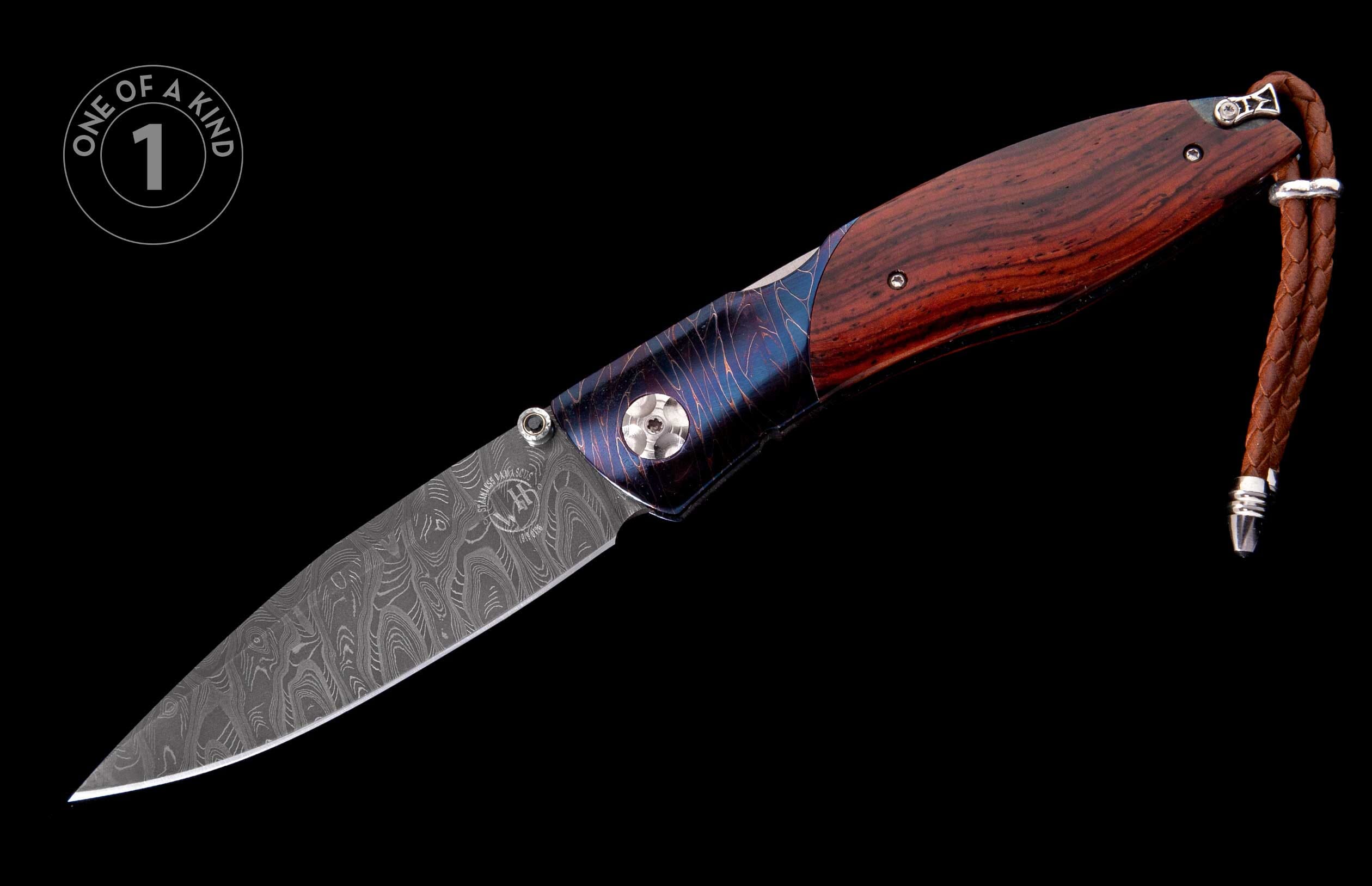 Dark wood folding knife with a patterned Damascus steel blade, blue-purple patterned bolster, and braided leather lanyard.