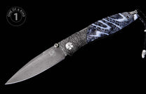 Folding knife with a dark Damascus steel blade and a black and white marbled handle, featuring a black leather lanyard.