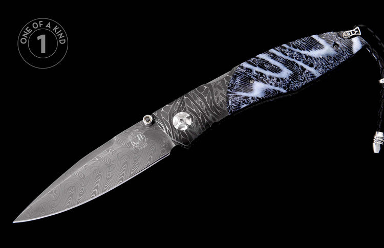 Folding knife with a dark Damascus steel blade and a black and white marbled handle, featuring a black leather lanyard.